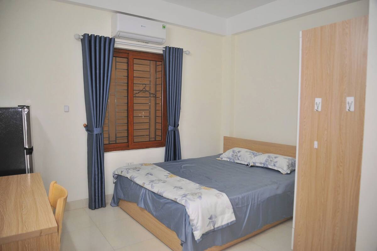 Une chambre à coucher avec un lit, une armoire en bois, un bureau et une chaise.