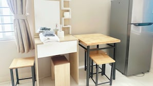 Eine kleine Küchenzeile mit Holztisch, eingebautem Spülbecken und Kühlschrank.