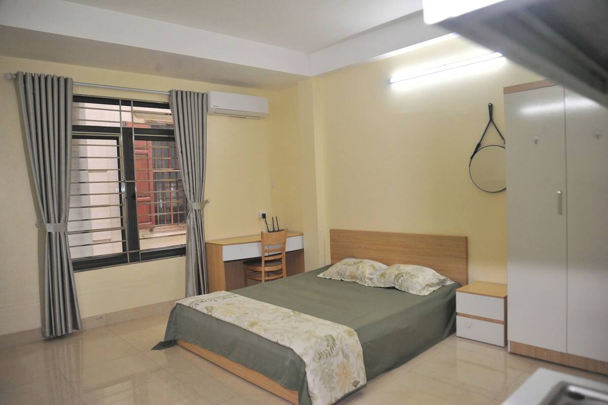 Une chambre à coucher avec un lit, un bureau et une armoire.