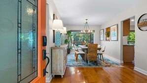 A modern interior with a dining area, wooden flooring, and a view through a glass door. - Lakefront Getaway w/Private Dock, Games and More (Hot Springs)
