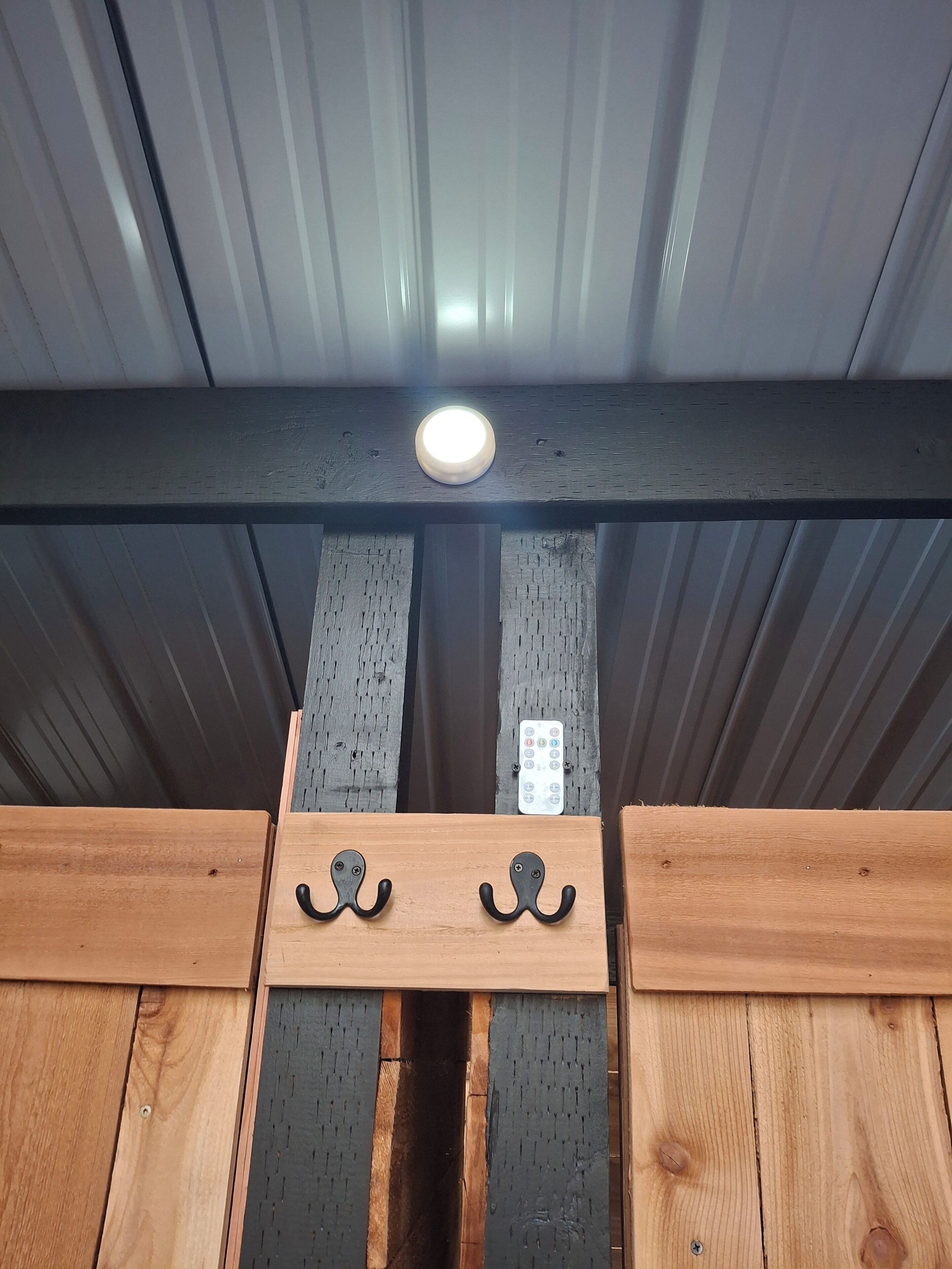 A ceiling with a recessed light fixture and a control panel.