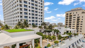 A high-rise building with a rooftop garden, outdoor seating area, and multiple balconies. - Gorgeous Jr Suite on Pool and Lanai Level of Hotel (Fort Lauderdale)