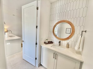 Chuveiro, secador de cabelo, toalhas de banho, shampoo