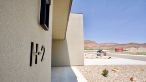 A building exterior with a number '1-2' sign, a concrete structure, and a gravel area with sparse vegetation.