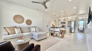 A modern living room with a sofa, coffee table, and dining area. - Red Rock Views & Stargazing near Zion & Bryce (Kanab)