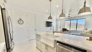 A modern kitchen with a stainless steel dishwasher, a sink, and pendant lighting. - Red Rock Views & Stargazing near Zion & Bryce (Kanab)