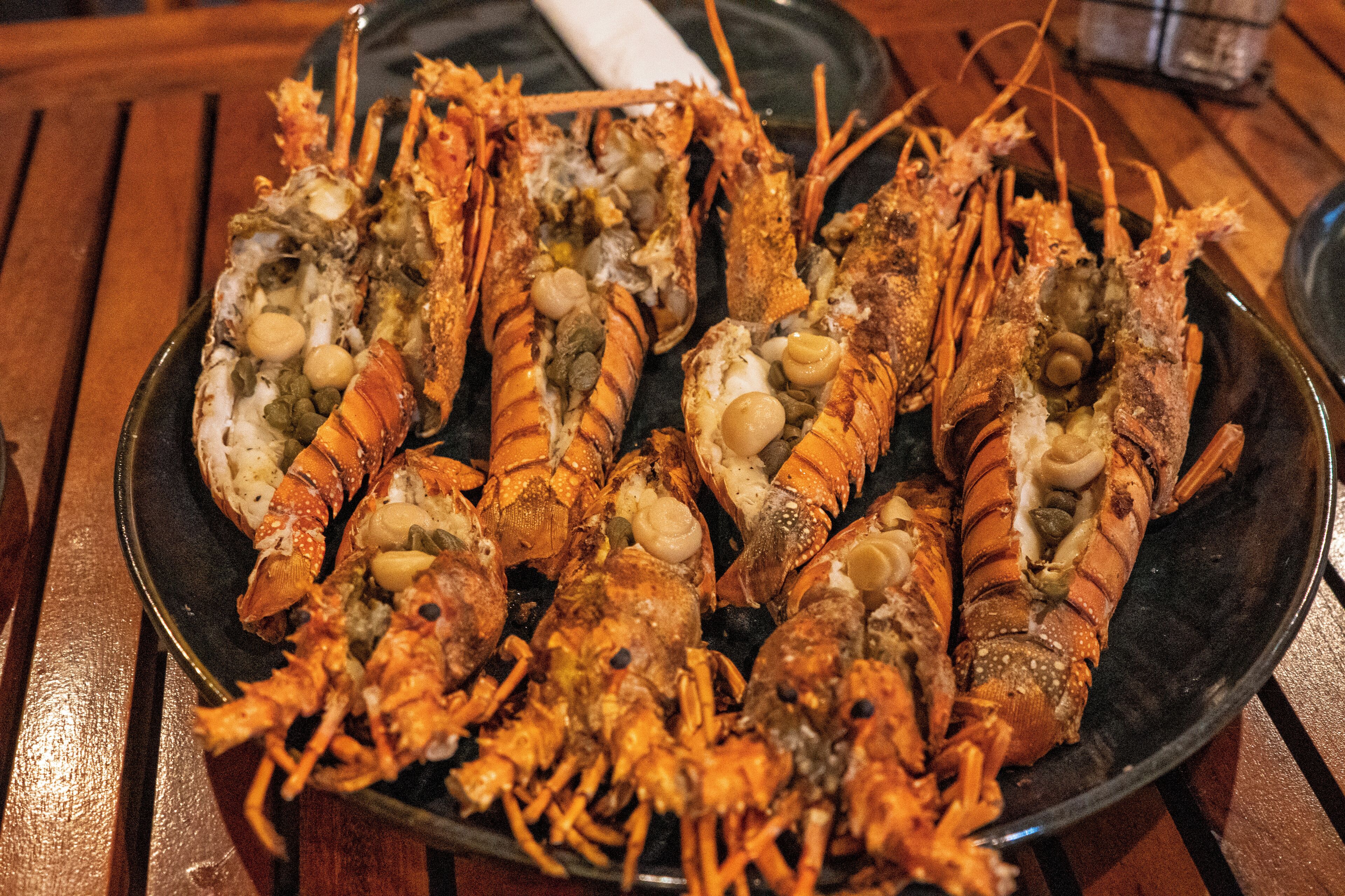 A plate of cooked lobsters with various toppings.