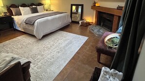 Um quarto moderno com um claraboia, uma cama grande, uma lareira e uma TV fixada na parede.
