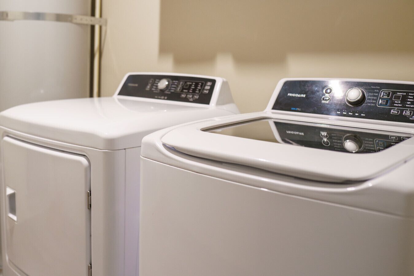 A front view of a washing machine and dryer in a laundry room.