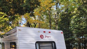 A Jayco RV parked in a wooded area.