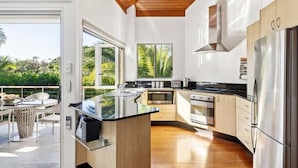 A modern kitchen with a central island, built-in appliances, and a view of the outdoors.