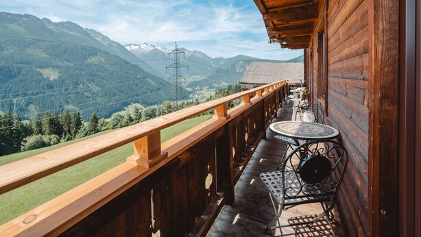A wooden balcony with a view of mountains and power lines. - Panoramaperle by Interhome (Neukirchen am Großvenediger)