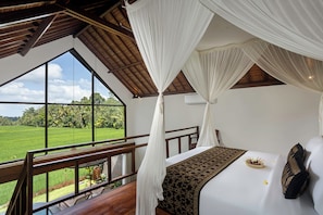 Een slaapkamer met een groot raam, een bed met hemelbed en uitzicht op een groen landschap.