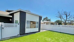 A modern single-story house with a garage, a fenced yard, and a well-maintained lawn.