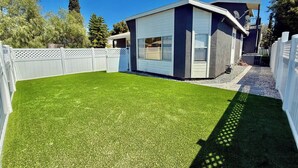 A modern house with a well-maintained lawn and a white fence.