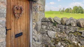 A rustic stone wall with a wooden door adorned with a heart-shaped wreath. - 2 bedroom accommodation in Skipton (Skipton)