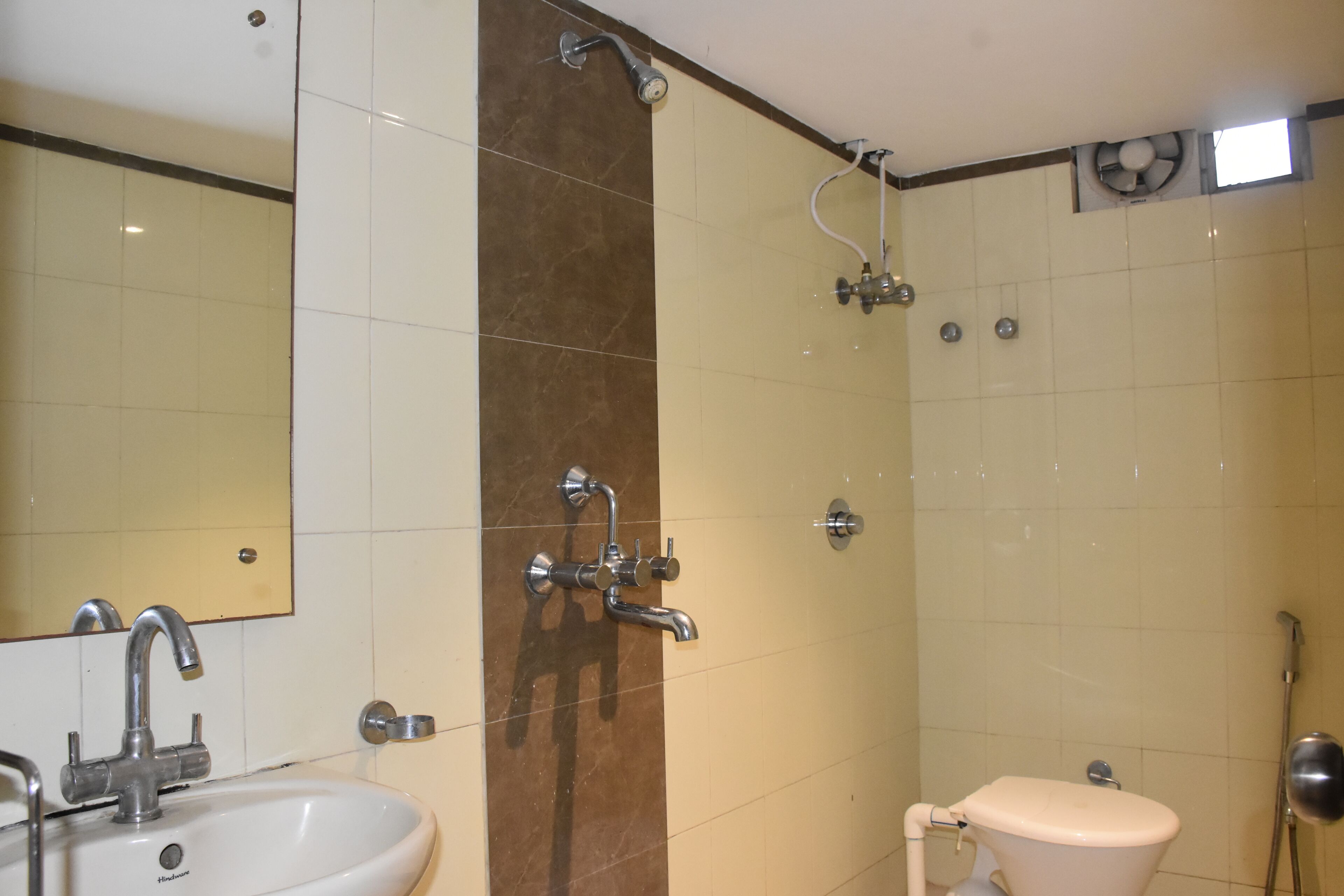 A bathroom with a sink, mirror, shower, and toilet.