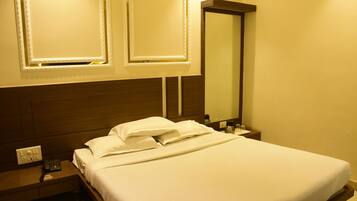 Una cama bien hecha con sábanas blancas en una habitación de hotel.