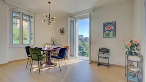 A dining area with a table, chairs, and a hanging light fixture. - Appartamento Vista Angera (Taino)