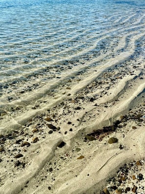 A beach with clear water, visible sand patterns, and scattered rocks. - Relax at The Deep Blue Nest –Family Friendly Getaway by the Ocean & Private Yard (Moss Beach)