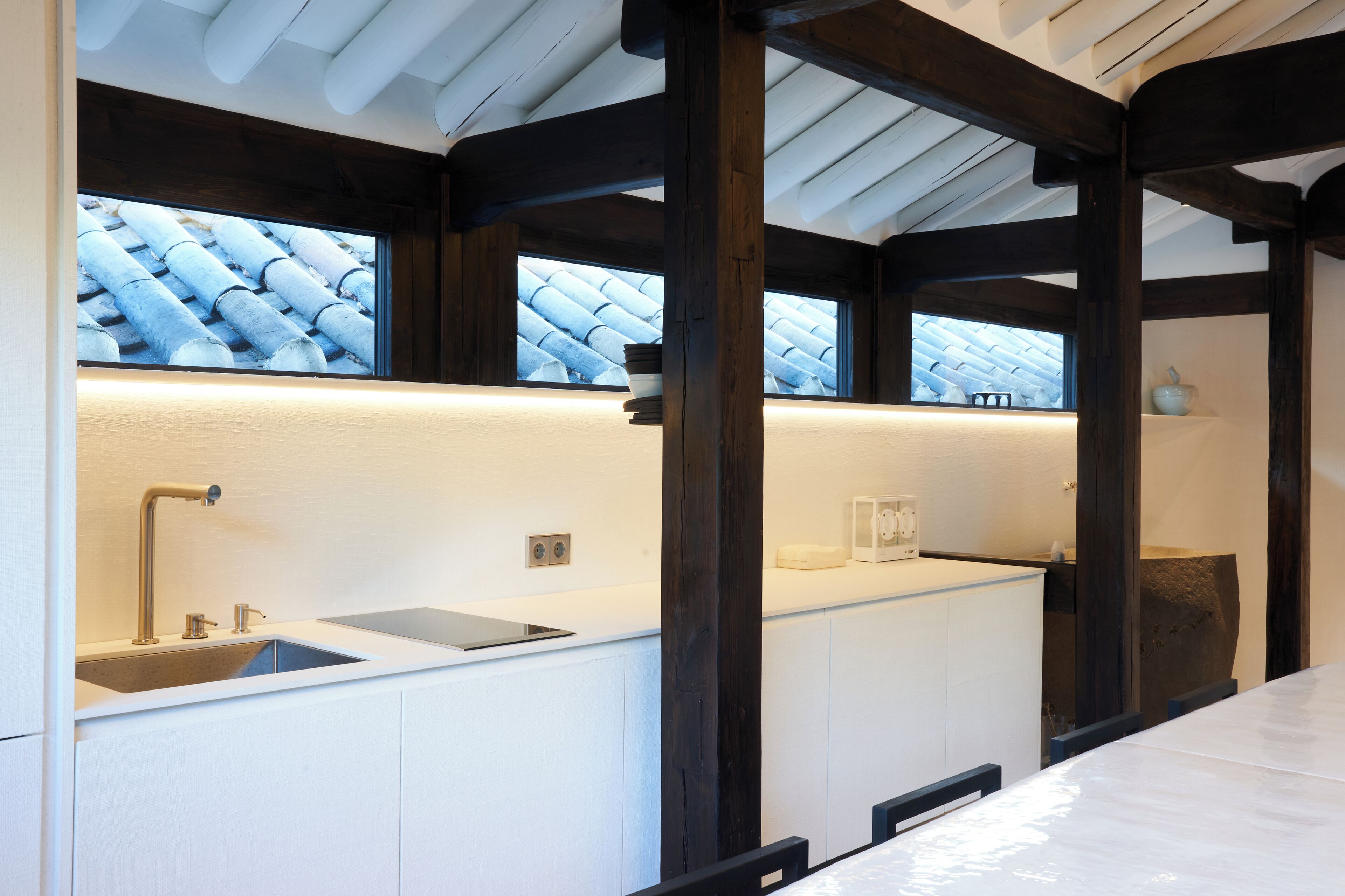 A modern bathroom with a large window, a sink, and a mirror.