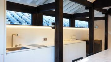 A modern bathroom with a large window, a sink, and a mirror.