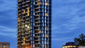 A tall, modern high-rise building with multiple balconies and large windows. - Downtown Calgary Haven - Steps to Stampede (Calgary)