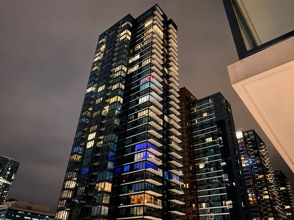 A high-rise building with multiple floors, large windows, and balconies.