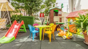 A playground with a slide, playhouse, and colorful plastic chairs and tables. - Cà d'Oro (Rimini)