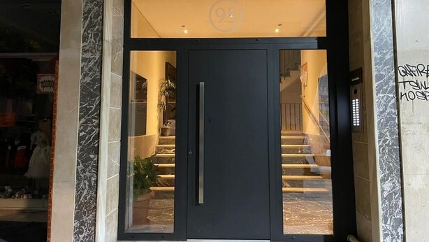 A modern hotel entrance with a dark door, glass panels, and a marble facade. - Selany's Chic Apt in the Heart of Athens (Athens)
