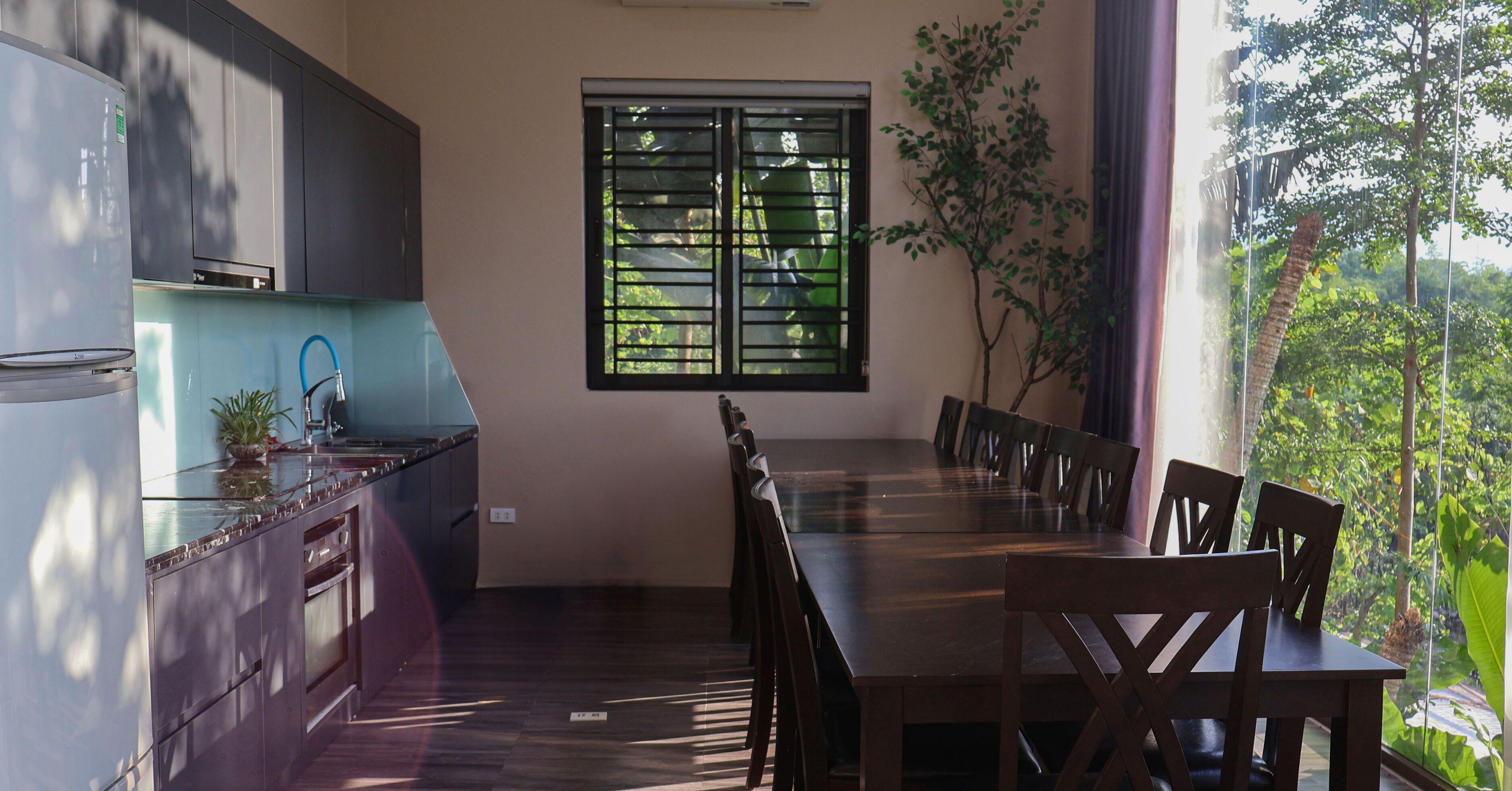 Uma cozinha moderna com mesa e cadeiras, uma janela com persianas e uma planta em vaso.