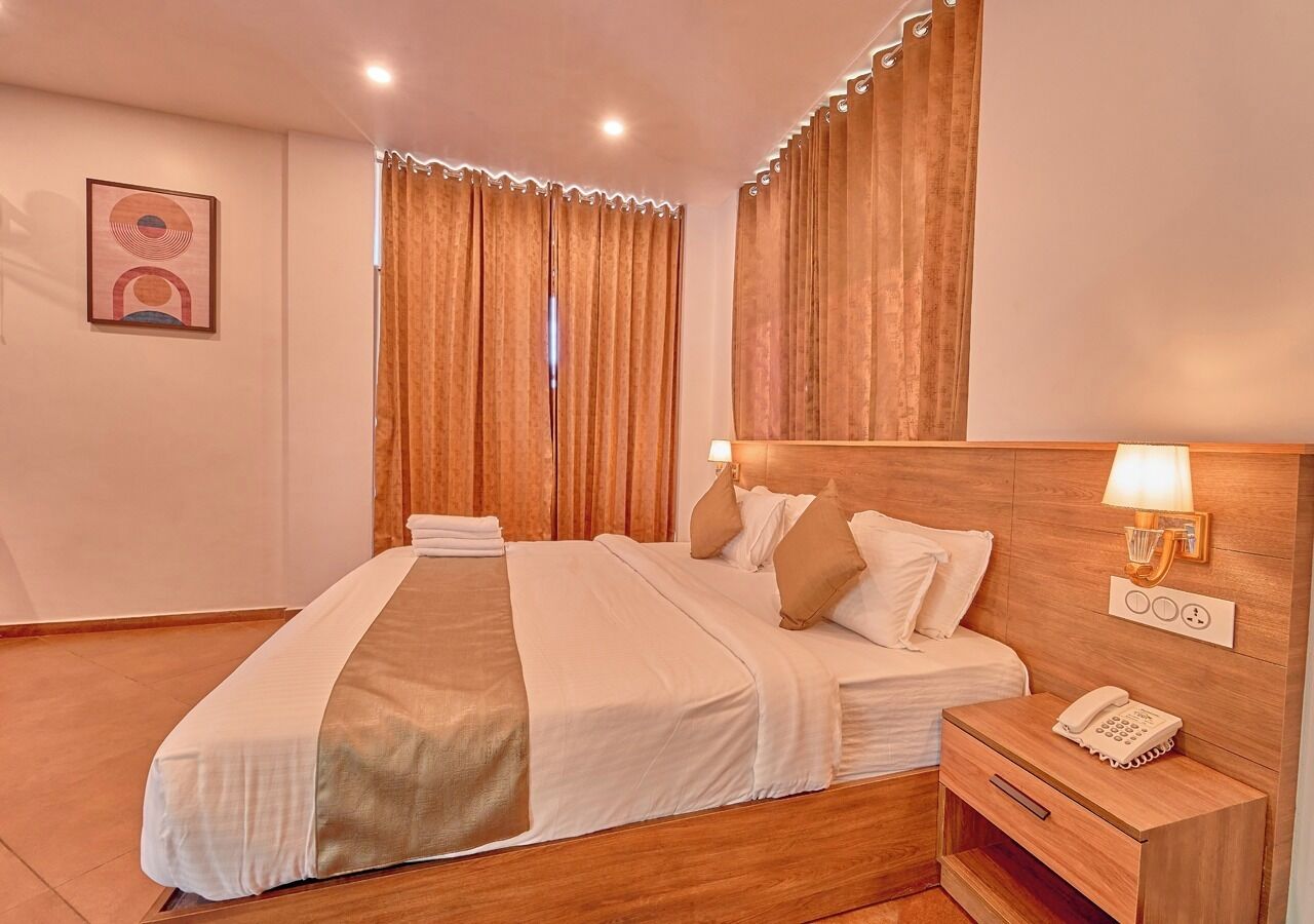 Ein Hotelzimmer mit einem hölzernen Bett, einem Nachttisch mit Lampe und einem Telefon.