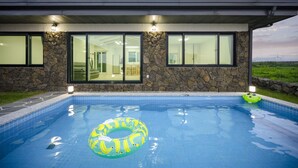 A modern house with a swimming pool, stone walls, and large windows. - Gimnyeong stonewall Private Pool Villa (Jeju City)
