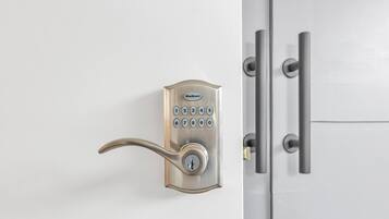 Een Kwikset deurslot met een numeriek toetsenbord en een hendel.