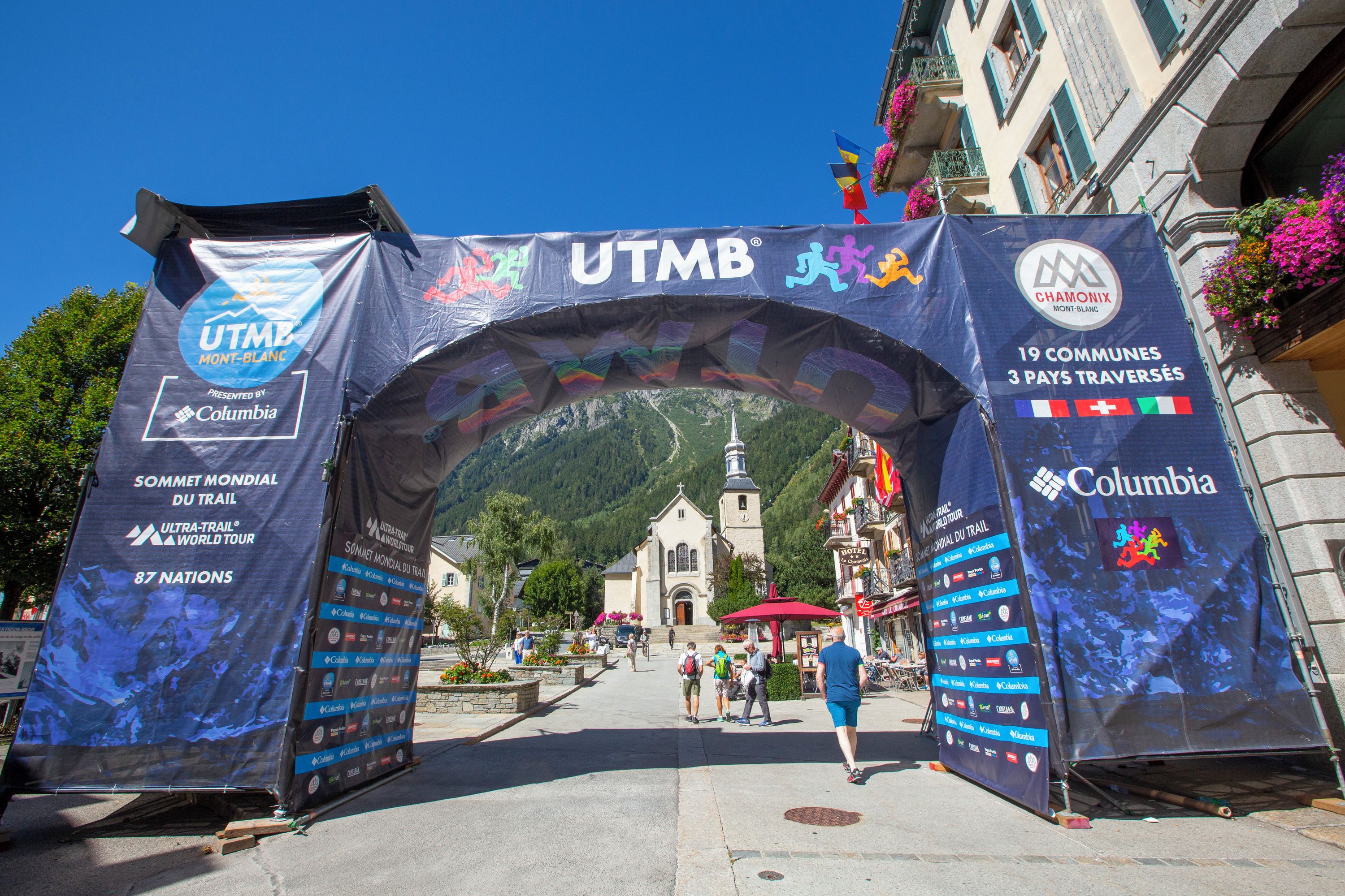 An archway with multiple banners and logos, including 'UTMB Mont-Blanc' and 'Columbia'.