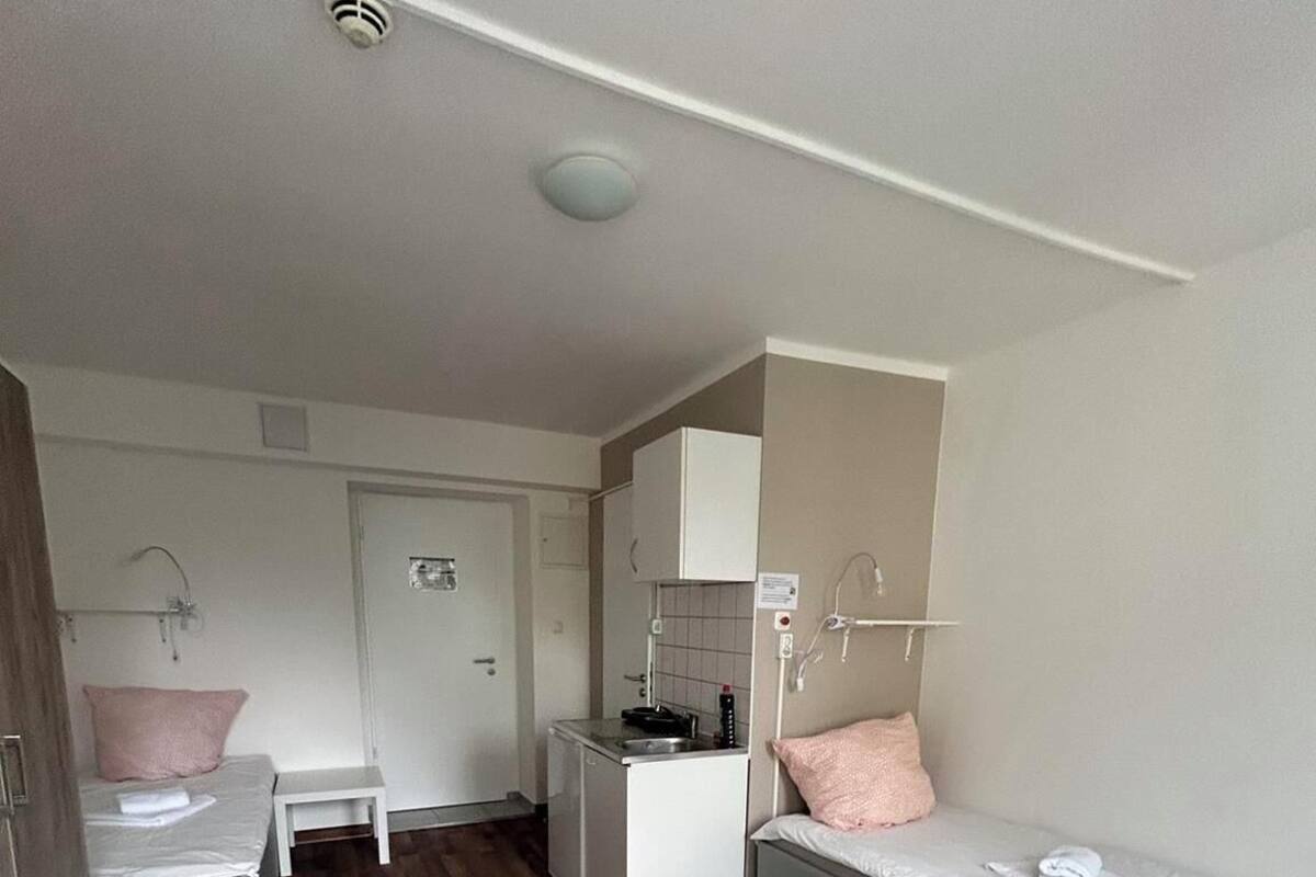 Une pièce compacte comprenant un coin cuisine, un lit et un espace salon.