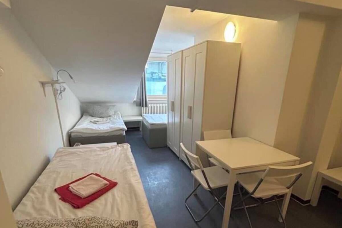 Une petite pièce, de taille modeste, comprenant un lit, un bureau et une armoire.