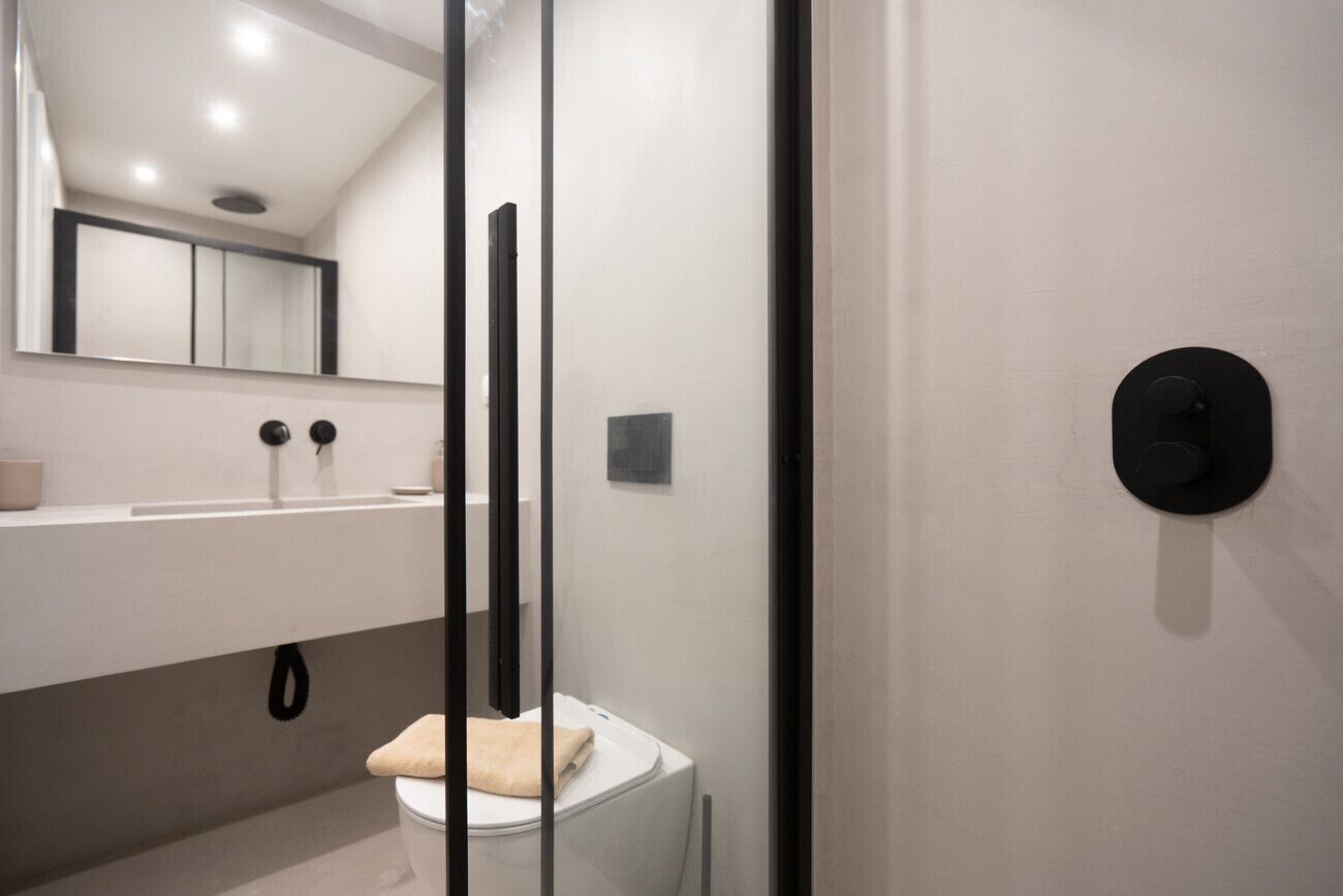 Ein modernes Badezimmer mit Toilette, Waschbecken und Spiegel.