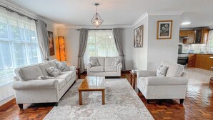 Amplia sala de estar con un ventanal grande, una mesa de centro de madera y dos sofás.