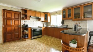 Una cocina con armarios de madera, estufa y pileta.
