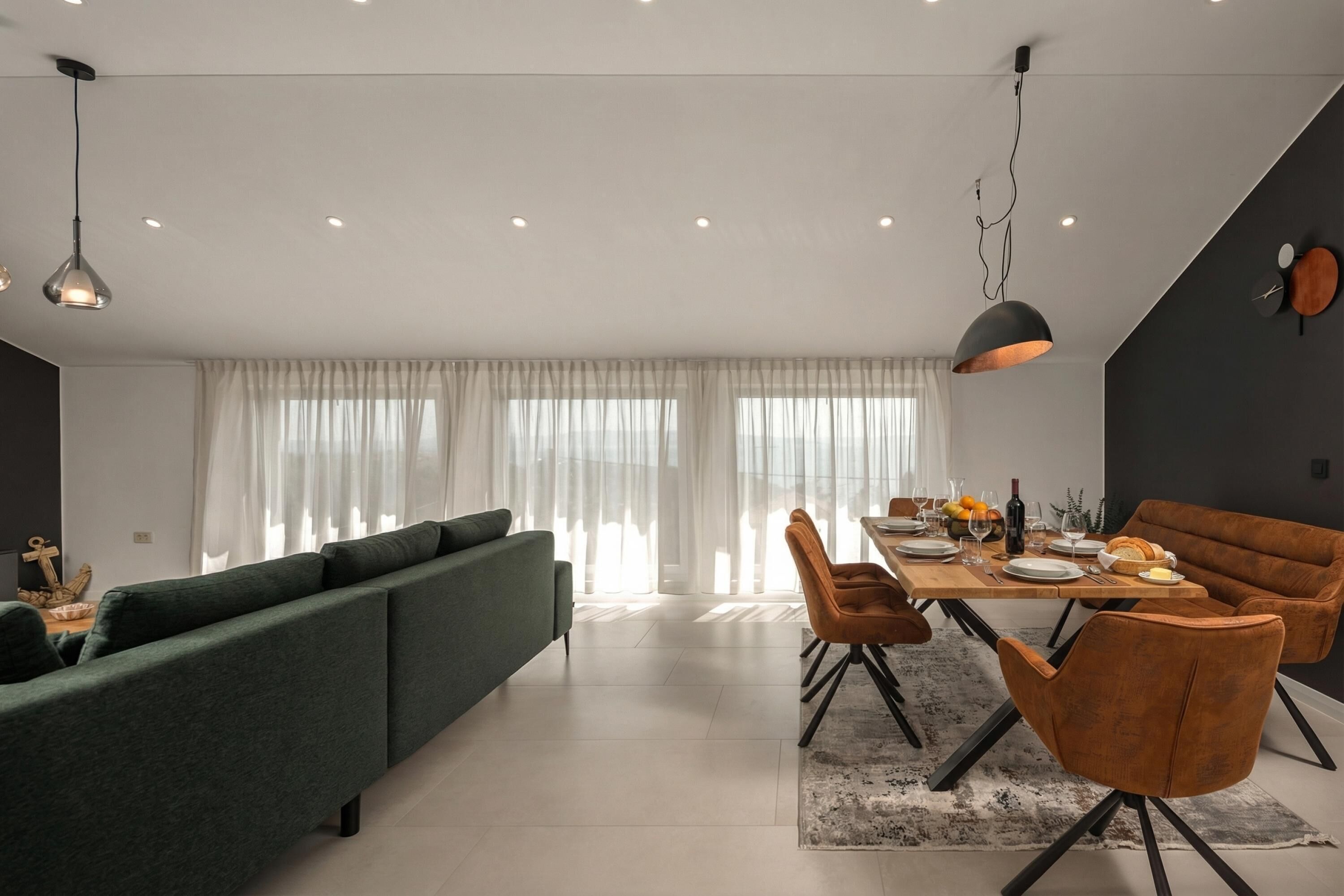 Een moderne eetruimte met een houten tafel voor vier personen, omringd door beklede stoelen.