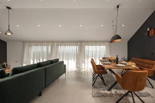 Un comedor moderno con una mesa de madera dispuesta para cuatro personas, rodeada de sillas tapizadas.