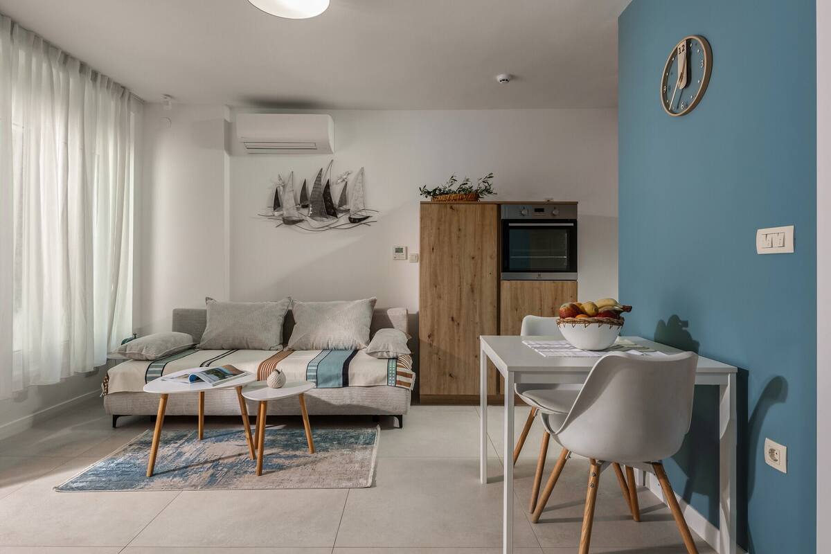 Una sala de estar moderna con sofá, mesa de centro y comedor.