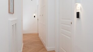 A hallway with white walls, wooden flooring, and a door with a light switch. - Tasso 41 House Sorrento City Center (Sorrento)