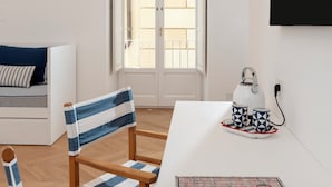 A modern living room with a white sofa, a striped chair, a table with a kettle and cups, and a large window with a view. - Tasso 41 House Sorrento City Center (Sorrento)