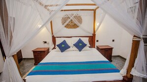 Ein Himmelsbett mit Baldachin, zwei Kissen, ein Nachttisch und ein an der Wand befestigtes Dekorationsstück.