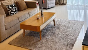 A modern living room with a sofa, armchair, coffee table, and a large window with curtains. - 2-bedroom apartment 127м² with a balcony 300m from the sea (Tambon Karon)