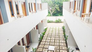 Un vaste espace intérieur doté d’un couloir central, de murs blancs et de portes en bois.