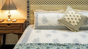 A bedroom with a bed, a nightstand, a lamp, and a framed picture on the wall.