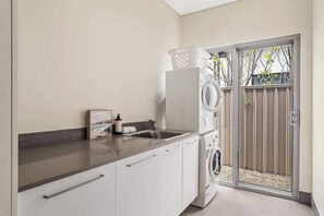 A laundry area with a washing machine, a dryer, and a sink.